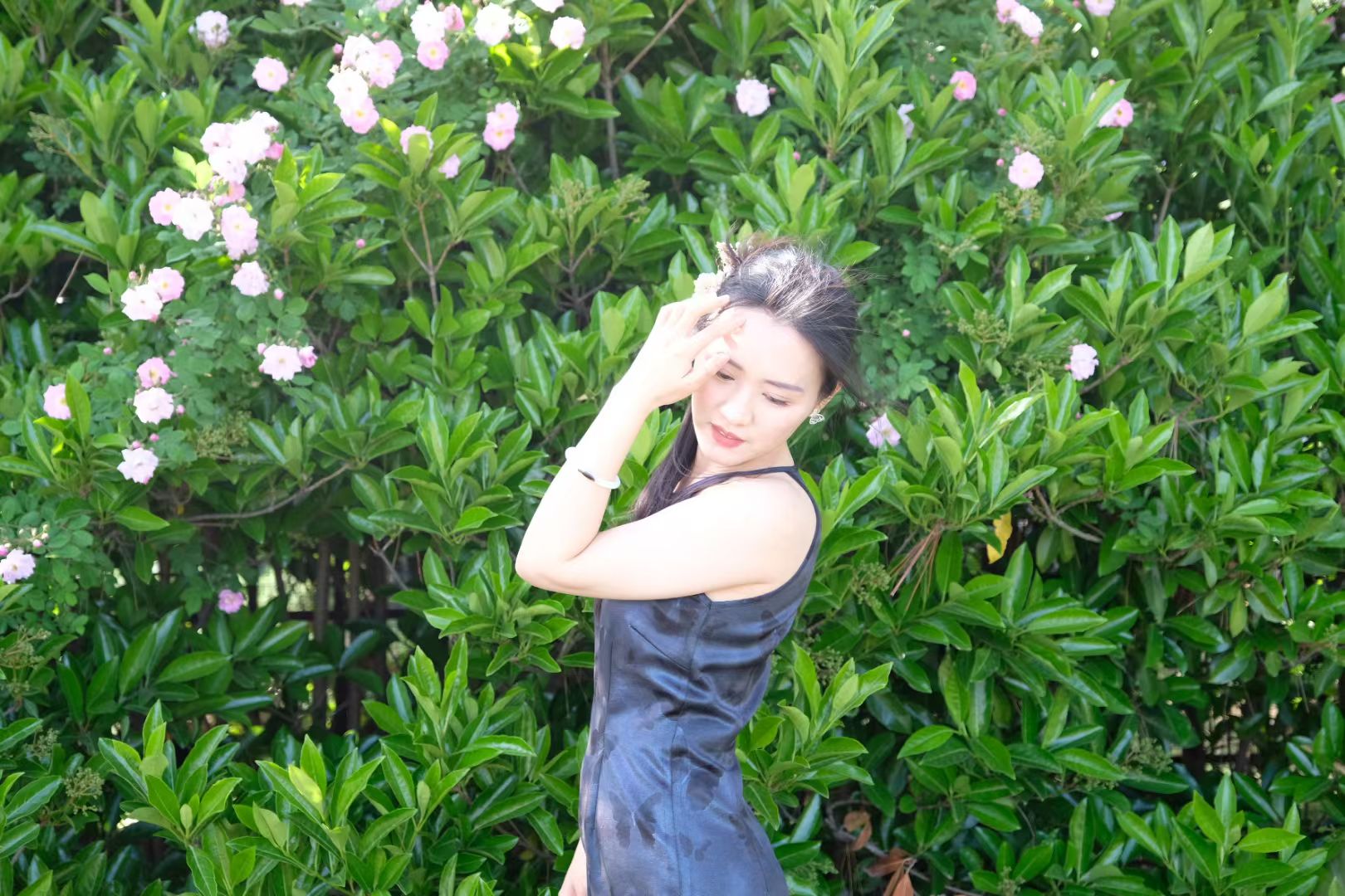 凤凤站在盛开的花和绿叶前